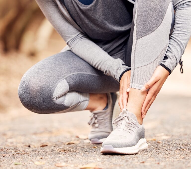 Person holding a rolled ankle after an injury, with a compression bandage
